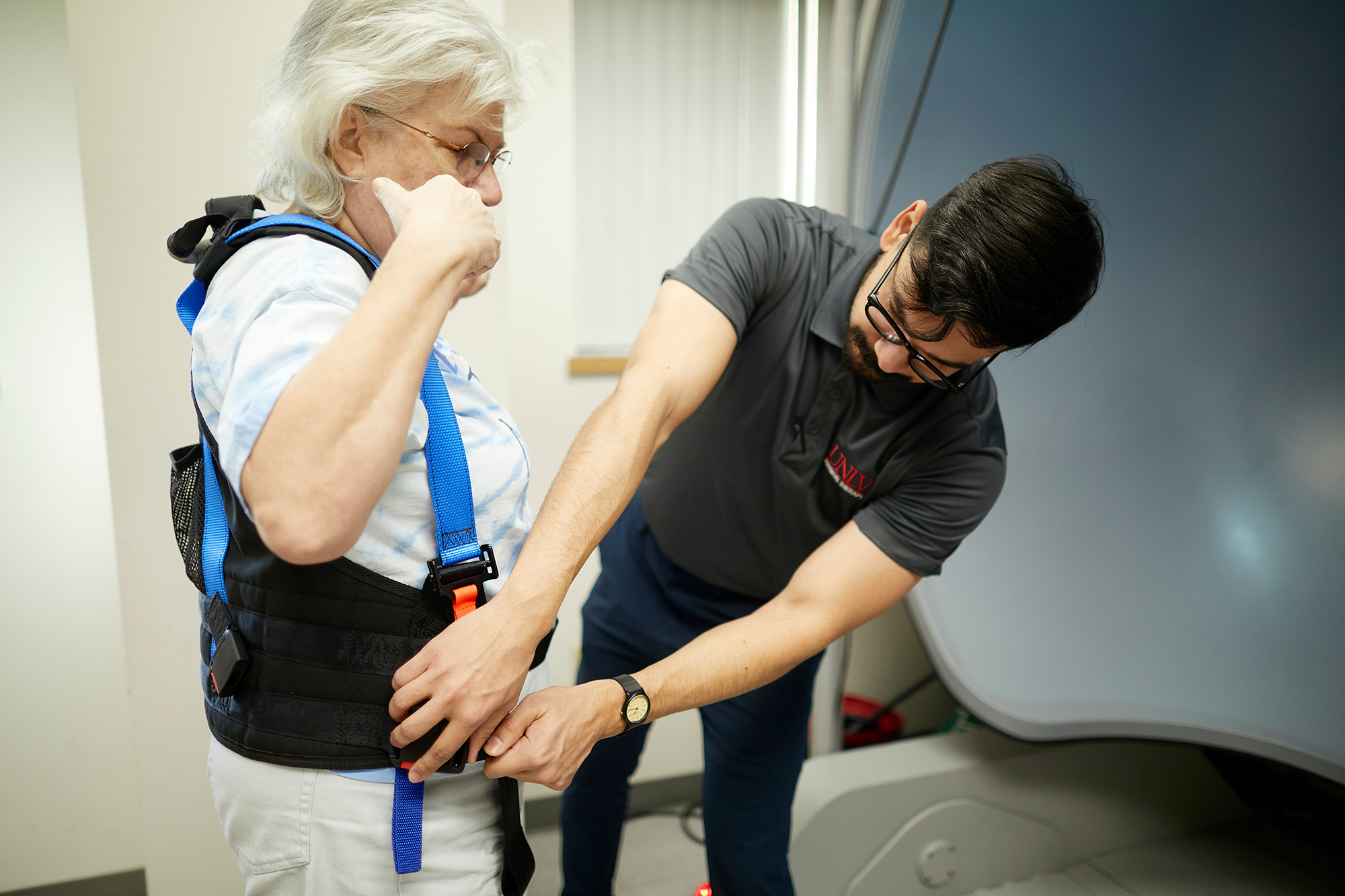 a man adjusting an old lady's vest