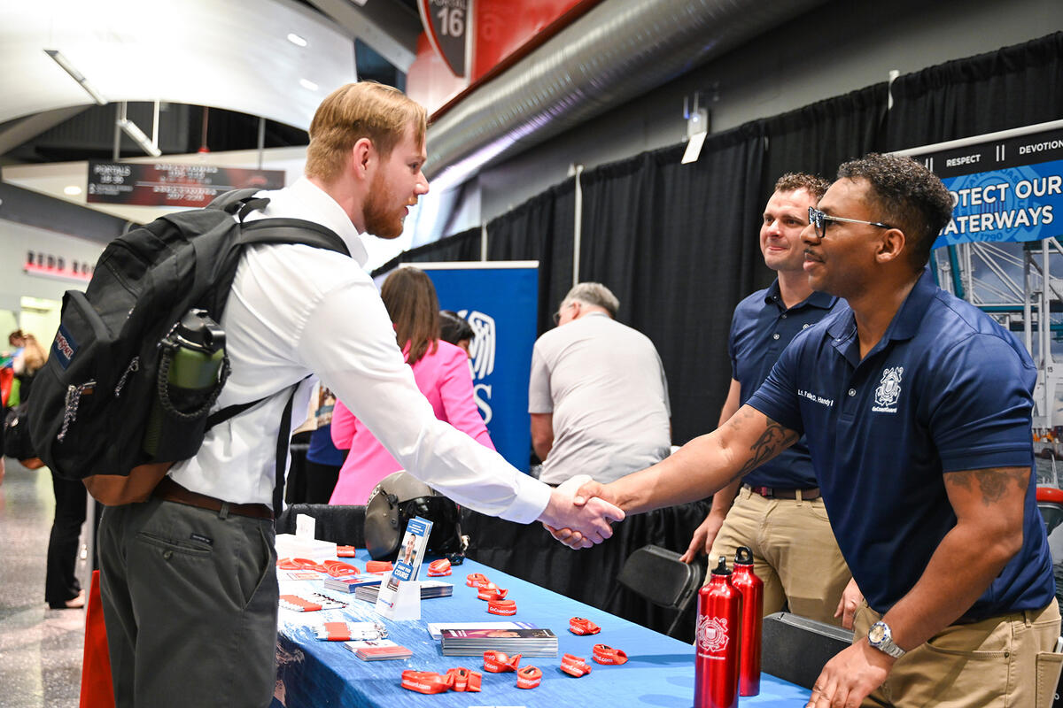 a person shaking hands with people who are on a table