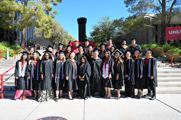 cohort of graduates stand in front of Flashlight sculpture