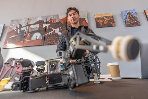 engineering-unlv_senior_design.jpg Young man standing behind a robot