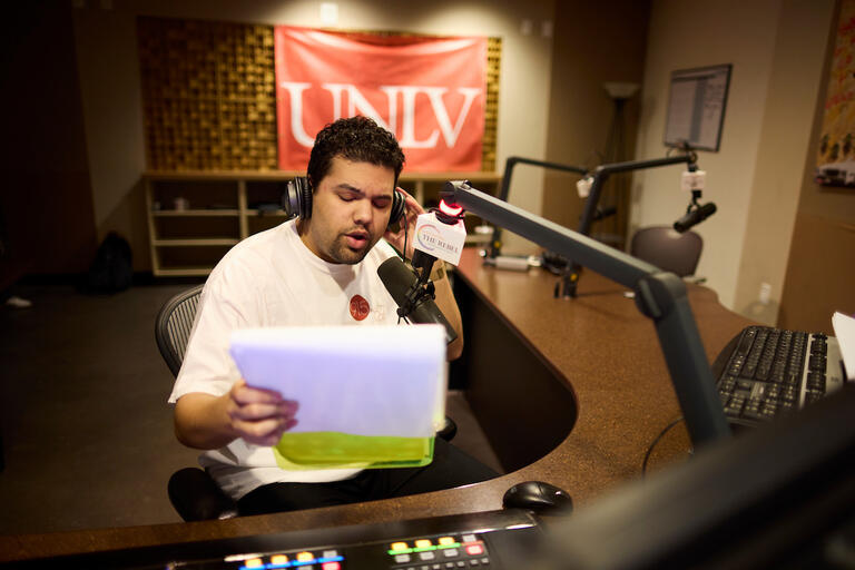 Student broadcasting live in the KUNV studio